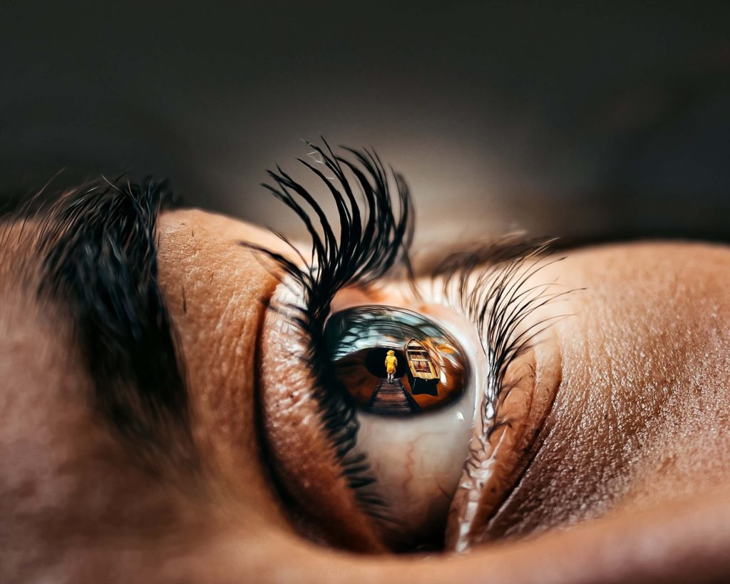 a close up eye with a child in the pupil